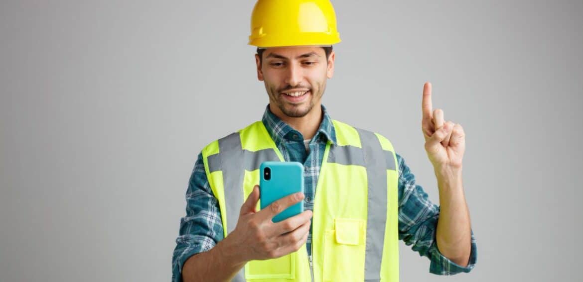 Construction worker holding smartphone, gesturing
